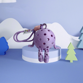 Purple toy with a keychain on a white base against a blue background