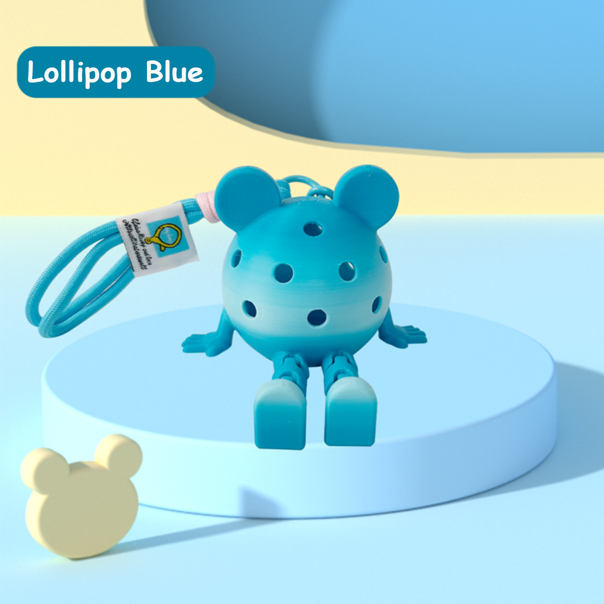 Blue toy with bear design on a light blue platform, labeled 'Lollipop Blue'.
