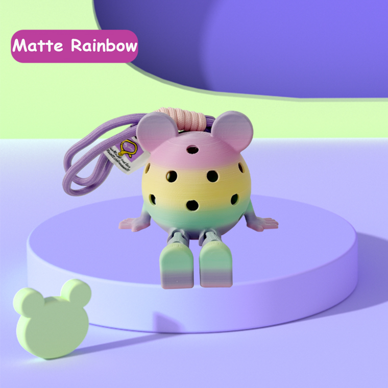 Colorful toy mouse with rainbow gradient on a purple platform, labeled 'Matte Rainbow'.